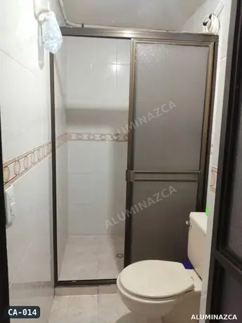 Cabina de baño corrediza en acrílico esmerilado, marco bronce – CA-014 | Aluminazca Medellín