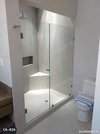 Cabina de baño en vidrio templado transparente, puerta batiente con panel fijo – CA-026 | Aluminazca Medellín